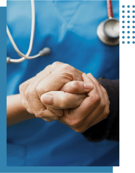 A nurse gently holding a patient's hand in a comforting gesture.